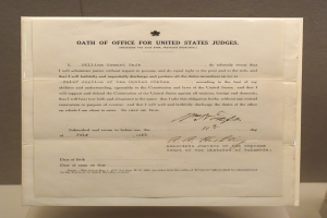 Ein Blatt Papier mit dem Text "Eid f├╝r US-Richter" darauf, das auf einem Tisch vor einer Wand liegt.