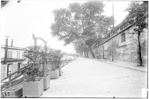 Eine schwarz-weiße Straßenansicht des New York State Penitentiaries mit einer Mauer auf der rechten Seite, Bäumen auf der linken Seite und einer Brücke im Hintergrund, beschriftet mit "New York City, New York, New Jersey, NY, USA, USA".