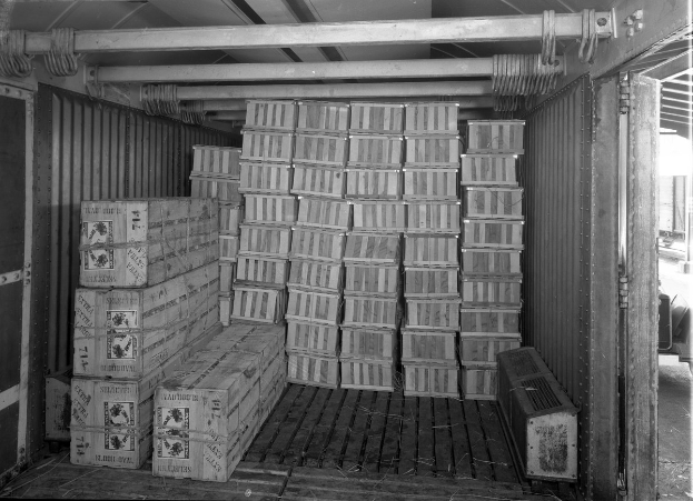 Kartonschachteln ordentlich in einem Transportcontainer gestapelt mit einem Objekt auf der rechten Seite.