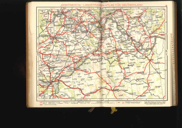 Offenes Buch mit einem detaillierten Straßen- und Autobahnplan von Deutschland auf schwarzem Hintergrund.