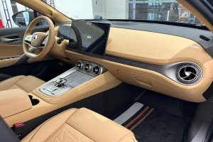 Das Innere eines Mercedes-Benz S-Klasse Limousinen auf der Frankfurter Motor Show, mit einem Lenkrad, Armaturenbrett, Bildschirmen, Knöpfen, Sitzen, Seitenspiegeln und Glasfenstern, durch die Menschen, Gebäude und andere Objekte im Hintergrund zu sehen sind.