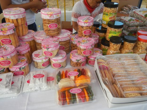 Menschen um einen Tisch mit verpackten Lebensmitteln auf einem Straßenfest.