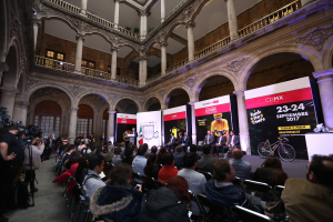 Eine Gruppe von Menschen sitzt an einem Tisch mit einem Podium und einem Mikrofon vor einer Menge, Kameras und Bannern, was auf eine Pressekonferenz f├╝r das CDMX 2017-Event hindeutet.