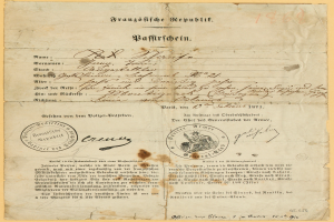 Ein altes, vergilbtes Dokument mit einem kreisrunden, schwarz umrandeten Stempel, wahrscheinlich ein Brief von der deutschen Regierung, geschrieben in schwarzer Tinte.